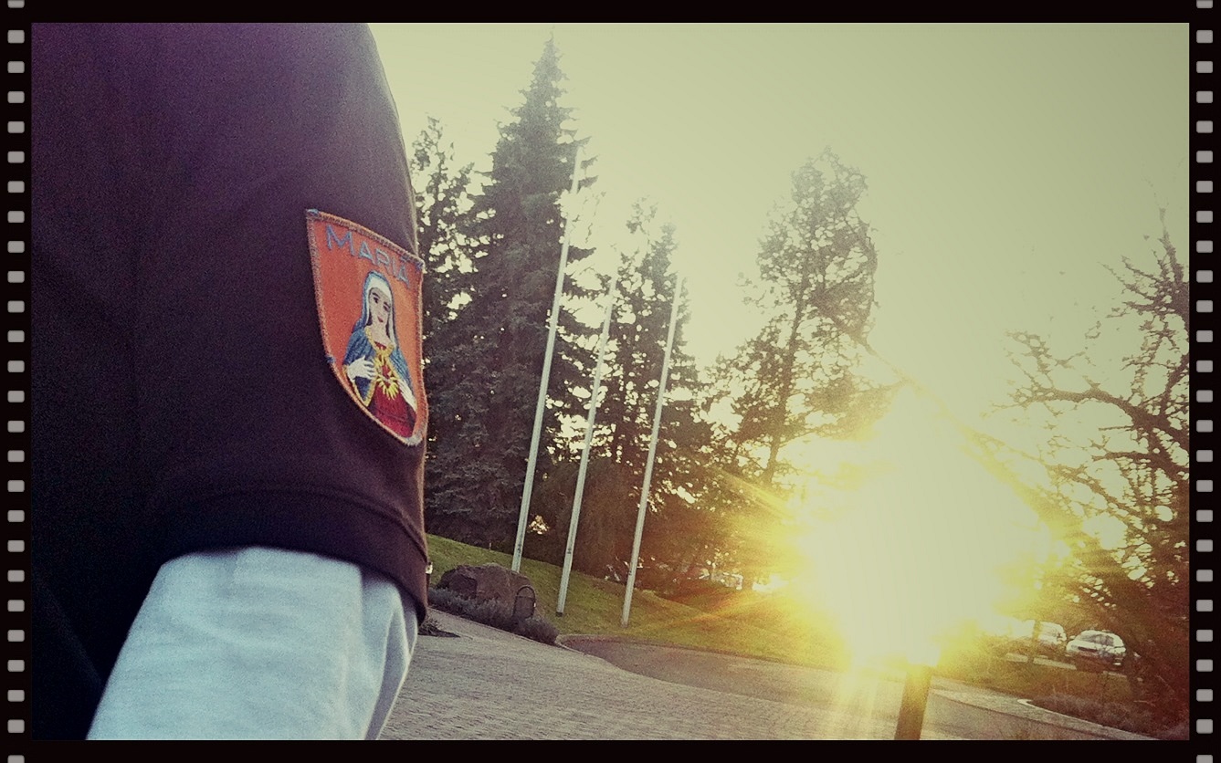Sleeve with the Mariä patch in front of flagpoles against the light